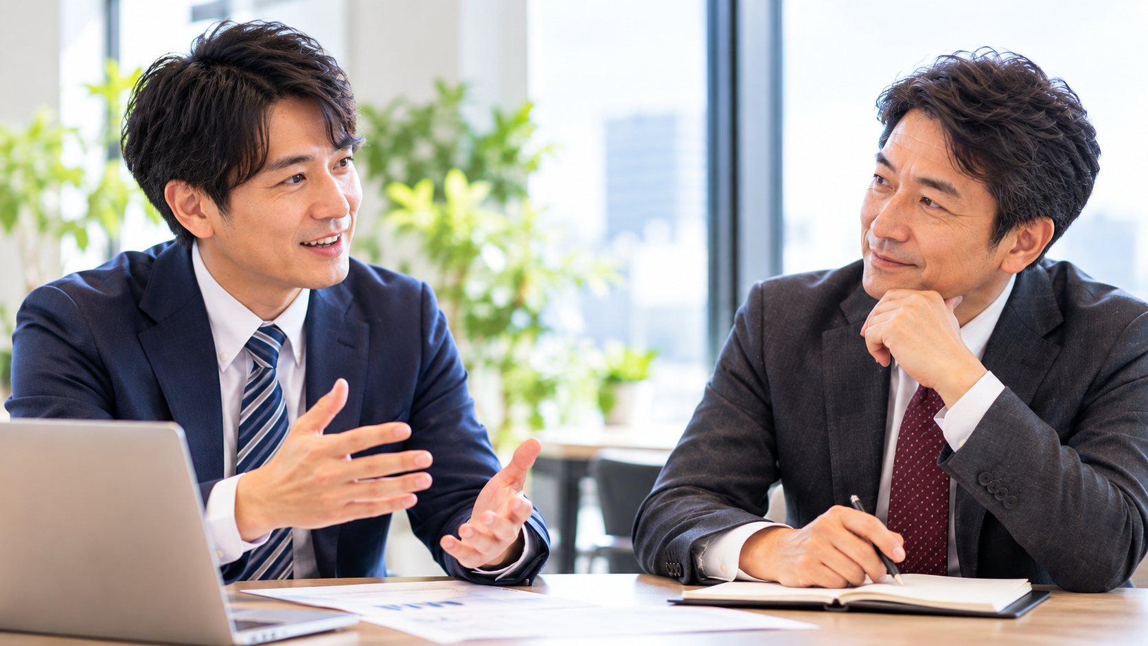 オフィスで営業担当者が手ごたえを話し、マネージャーがうなずきながら聞いている様子
